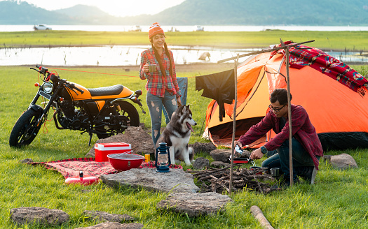 couple lover enjoy camping countryside with campfire, Traveling by motorcycle of the couple lover, Great warm evening
