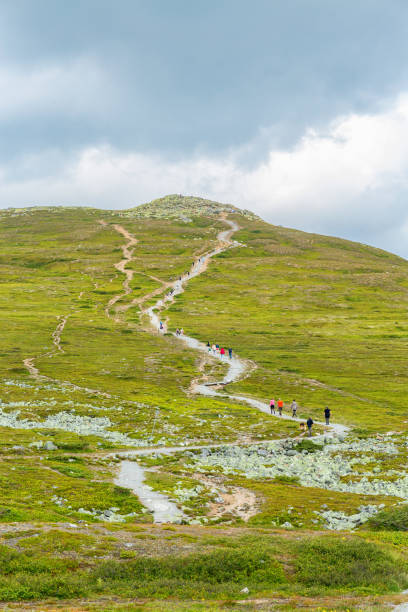 istock People walking on a hiking trail to a mountain peak 1153454333