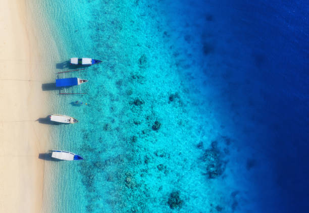 istock Boats on the water surface from top view. Turquoise water background from top view. Summer seascape from air. Gili Meno island, Indonesia. Travel - image 1153454855