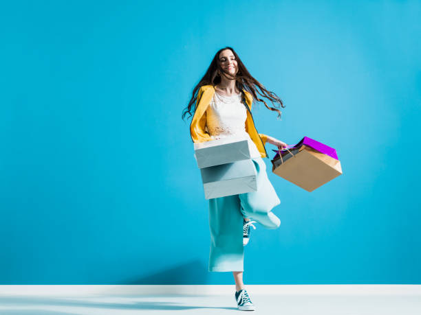 istock Cheerful young woman enjoying shopping 1153458437