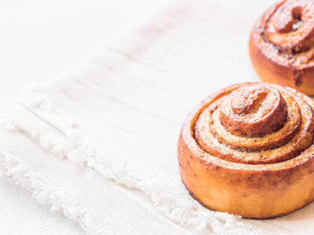 istock Confectionery baking. Sweet fresh soft roll bun with cinnamon on white background. Cinnabon closeup 1153458542