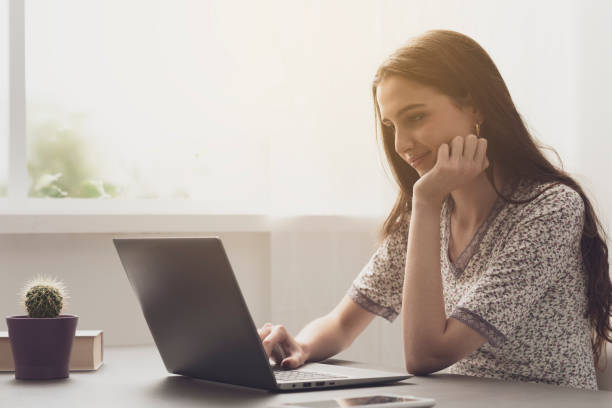 istock Young woman working with her laptop at home 1153458810