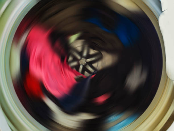 istock Top view of a washing machine drum during spinning clothes. Top loading washing machine washes laundry. 1153459897