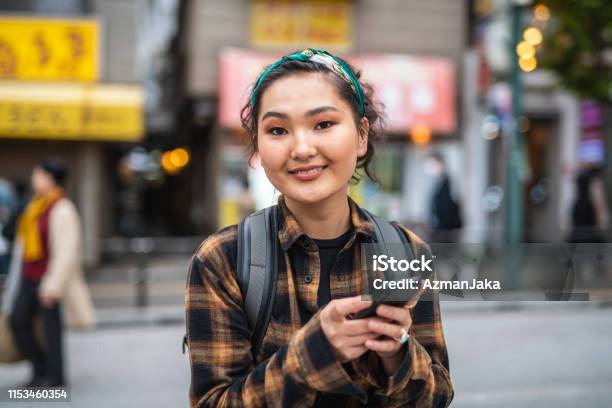 Young Mongolian Female Traveler Texting In Tokyo Stock Photo - Download Image Now - Mongolian Ethnicity, People, One Person