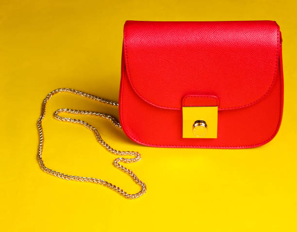 istock Red leather mini bag with chain on yellow background. 1153461518