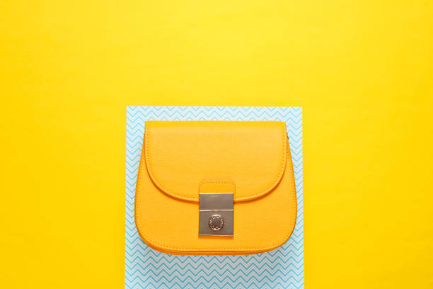 istock Women's yellow leather bag on a creative background, minimalism 1153461623