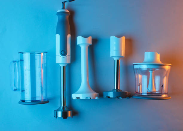 istock Electric hand blender with nozzles on neon blue orange light background. Top view, Flat lay 1153462080