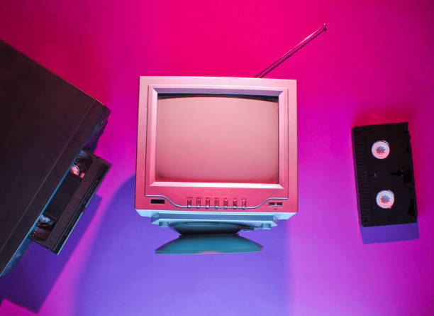 istock Retro wave, 80s concept. Video player with vhs cassette, old tv, neon light. Top view, flat lay 1153462136