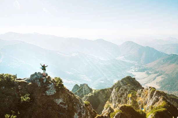 istock Mountain hiker with backpack tiny figurine stands on mountain peak with beautiful panorama 1153462938