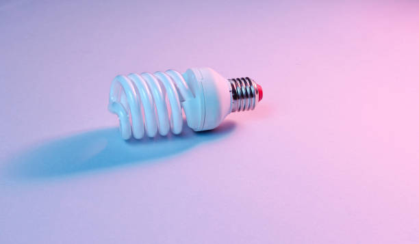 istock Spiral eco light bulb on neon light background. Minimalism concept 1153463150