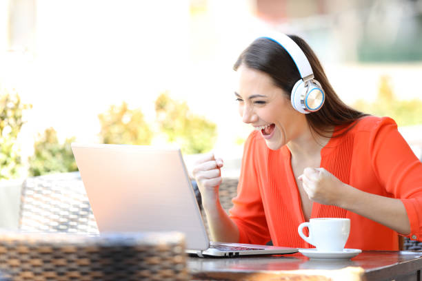 istock Excited woman watching and listening media on laptop 1153463473