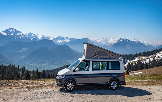 Popup Campervan, Jura, French Alps - May 10, 2019: camping with small lifting roof van in snow covered mountains of France.