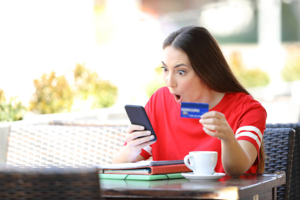 istock Shocked student paying online with credit card in a bar 1153463585