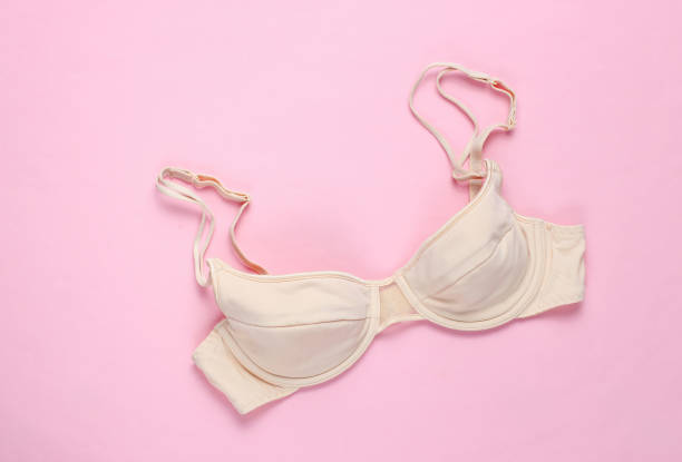 istock Beige feminine bra on a pink background. Top view, minimalism 1153464876