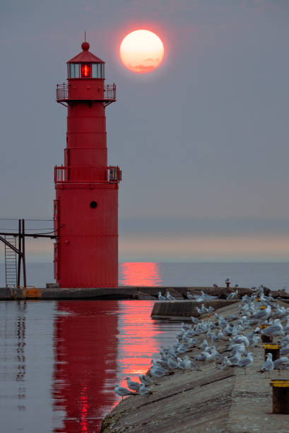 istock Glowing Red Ash Sunrise With Lighthouse 1153466014