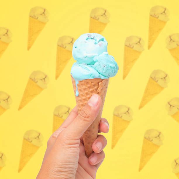 istock woman hand holding wafer cone with blue  ice cream on pattern background 1153466251