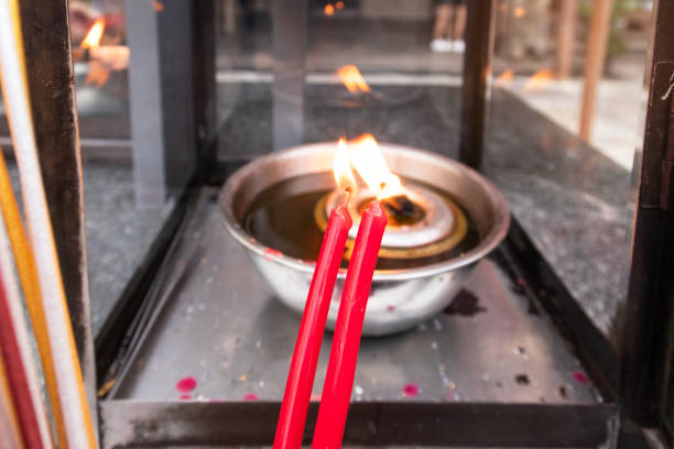 Two red candle burning on fire of lanterns for respect to old shrine.