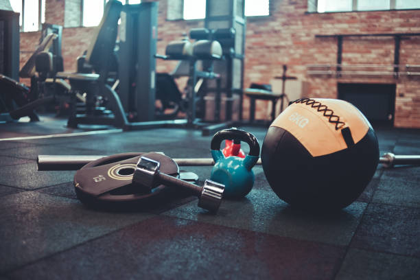 Disassembled barbell, medicine ball, kettlebell, dumbbell lying on floor in gym. Sports equipment for workout with free weight. Functional training Disassembled barbell, medicine ball, kettlebell, dumbbell lying on floor in gym. Sports equipment for workout with free weight. Functional training circuit training stock pictures, royalty-free photos & images