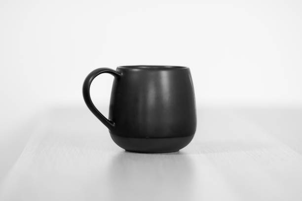 istock Black tea or coffee cap on the white wooden table on white background. 1153467891