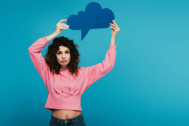 istock sad curly redhead girl holding thought bubble on blue 1153470043