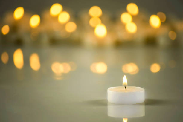 istock A lit white candle on a background of blurred lights 1153471455