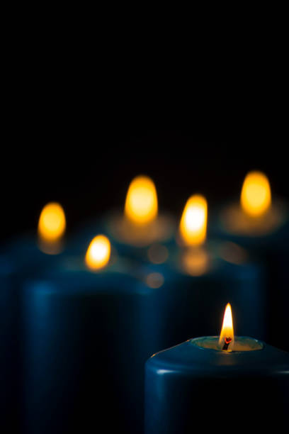 istock Lit blue candles on a black background 1153471603