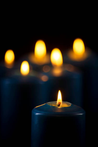 istock Lit blue candles on a black background 1153471634