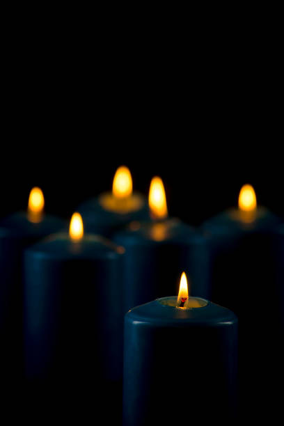 Lit blue candles isolated on a black background