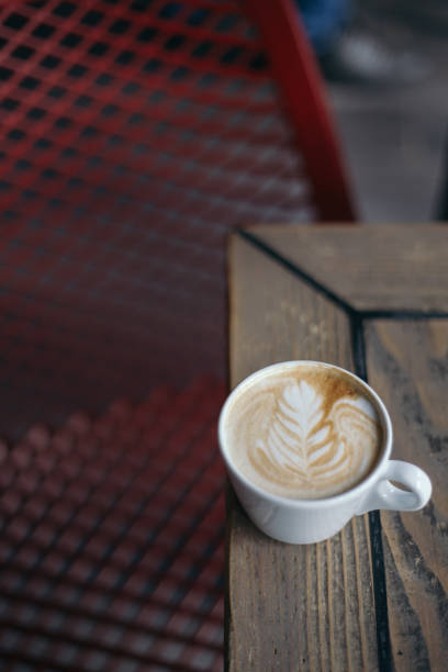 istock Coffee with latte art on wooden table with blurry background 1153472362