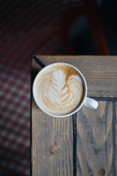istock Coffee with latte art on wooden table with blurry background 1153472369