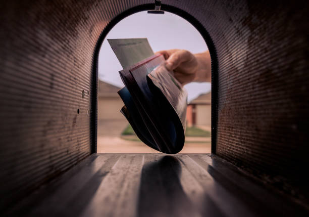 Mailman Delivering Mail A hand placing mail in a mailbox. mailbox stock pictures, royalty-free photos & images