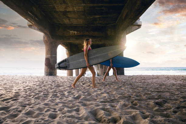 女性の友人はサーフィンに行く - santa monica surfing beach city of los angeles スト�ックフォトと画像