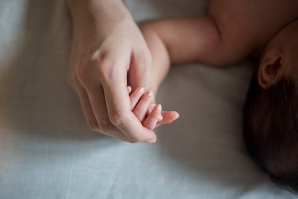 istock Close up of newborn hand in the hand of mother while sleeping 1153473239