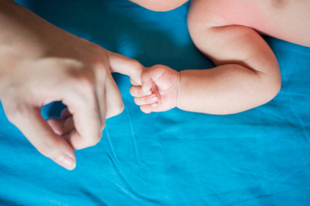 istock Close up of newborn hand in the hand of mother while sleeping 1153473279