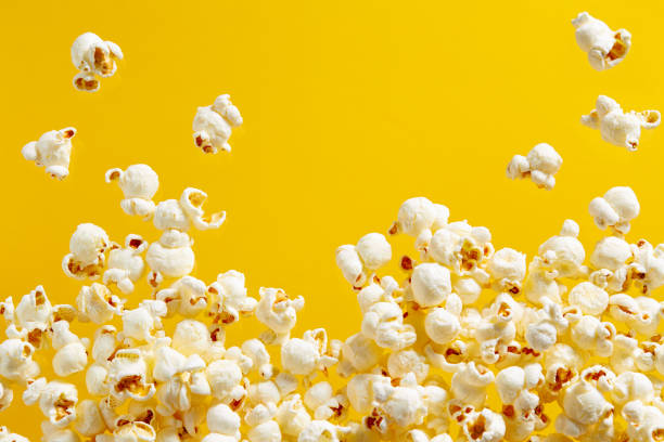 popcorn på gul bakgrund - popcorn bildbanksfoton och bilder