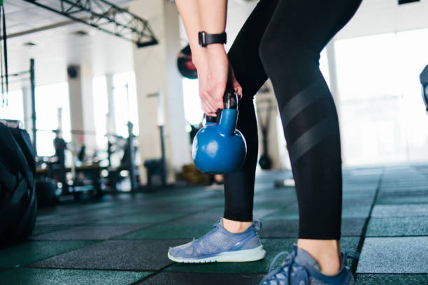 istock Functional training with a kettlebell. Closeup woman doing exercise with kettlebell in gym 1153476005