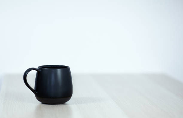 istock Black tea or coffee cap on the wooden table on light grey background. 1153477408