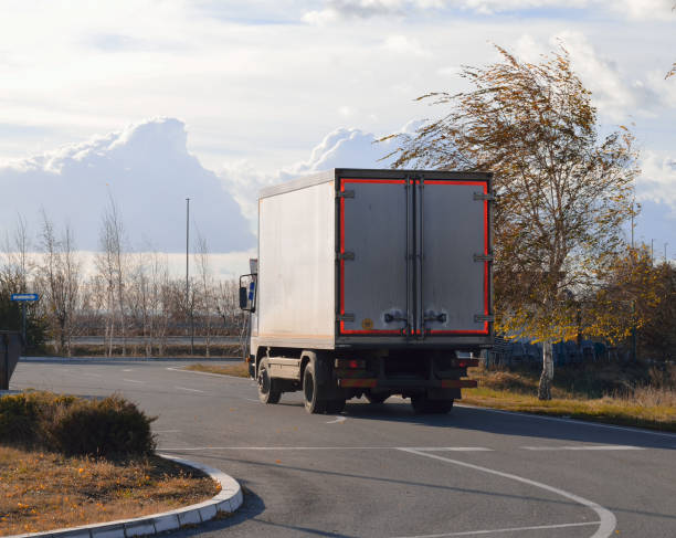 istock Speeding white semi truck with cargo trailer entering highway 1153478882