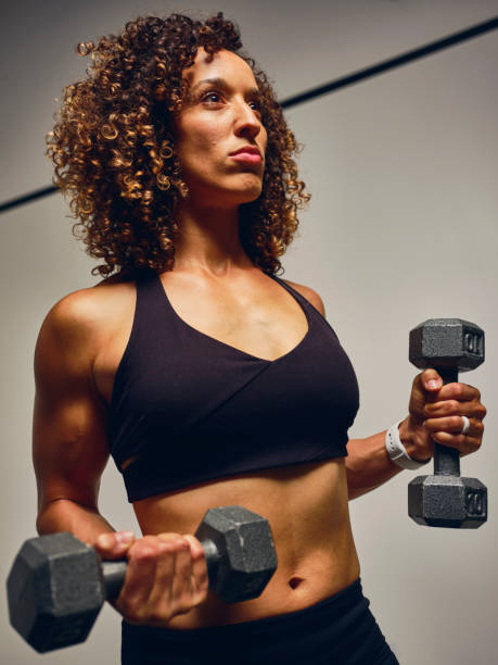 istock Young Woman Athlete Working Out with Dumbbells 1153479038