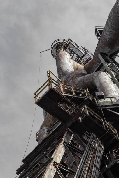 istock Looking up from beneath at an old steel mill before gray skies 1153483244