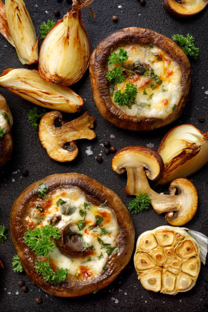 구운 포토 벨로 버섯은 치즈와 검은 철 바탕에 허브로 채워진, 평면도. - edible mushroom stuffed portabello mushroom vegetarian food 뉴스 사진 이미지