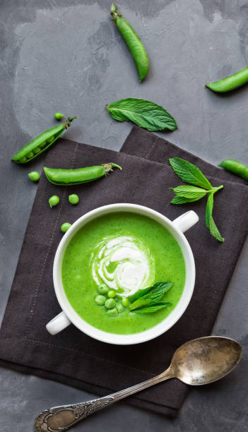 sopa da ervilha verde e da hortelã na bacia no fundo concreto cinzento - pea and mint soup - fotografias e filmes do acervo