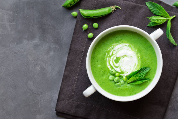 istock Green pea and mint soup in bowl on gray concrete background 1153487880