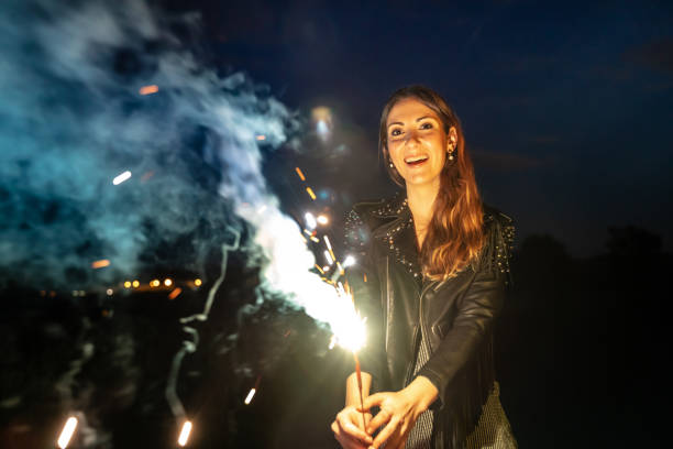 istock Woman holding a sparkler at night 1153487992