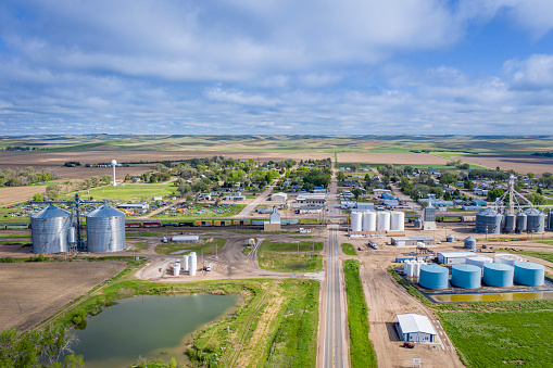 Brule, NE, USA - May m27, 2019: Aerial view of rural town in Nebraska Sandhills with agricultural industry and passing cargo train.