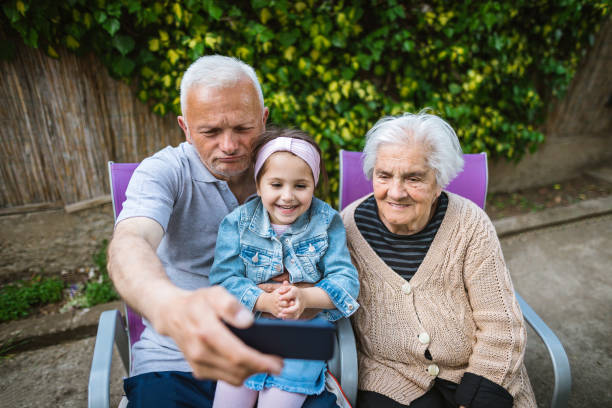 Playful grandparents amuse granddaughter Cheerful 4 year old child enjoy spending time with her grandparents in backyard of their house. amuse stock pictures, royalty-free photos & images