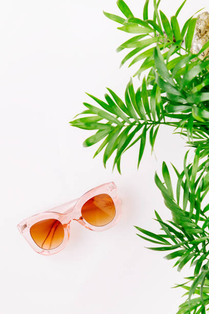 istock Tropical leaves and sunglasses   on a white  background with space for text. Top view, flat lay. 1153496106