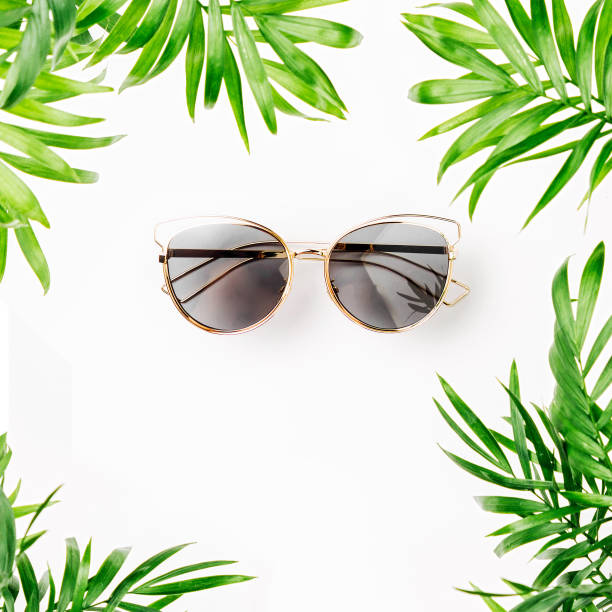 istock Tropical leaves and sunglasses   on a white  background with space for text. Top view, flat lay. 1153496167
