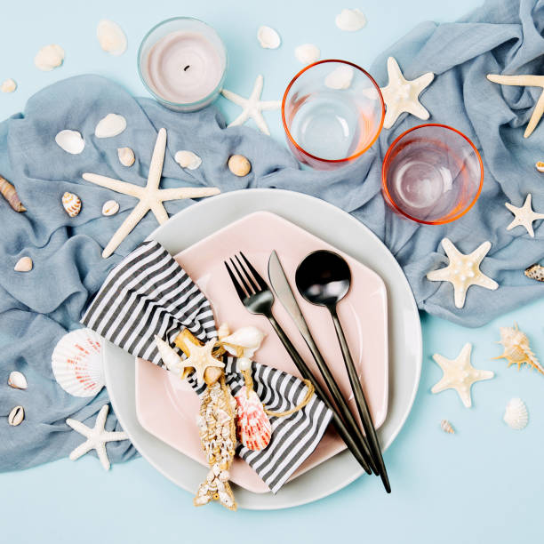 istock Table Setting and sea decorations for serving a festive table. Plates, wine glasses and cutlery on blue background. Summer concept. Flat lay, top view 1153496271