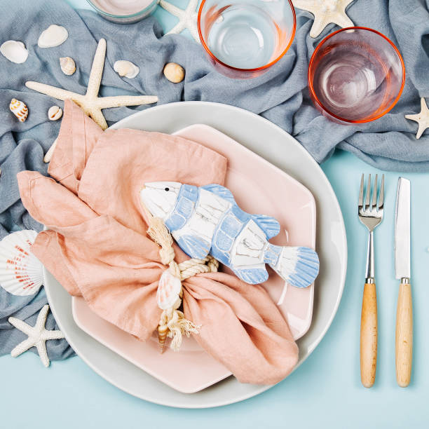 istock Table Setting and sea decorations for serving a festive table. Plates, wine glasses and cutlery on blue background. Summer concept. Flat lay, top view 1153496468